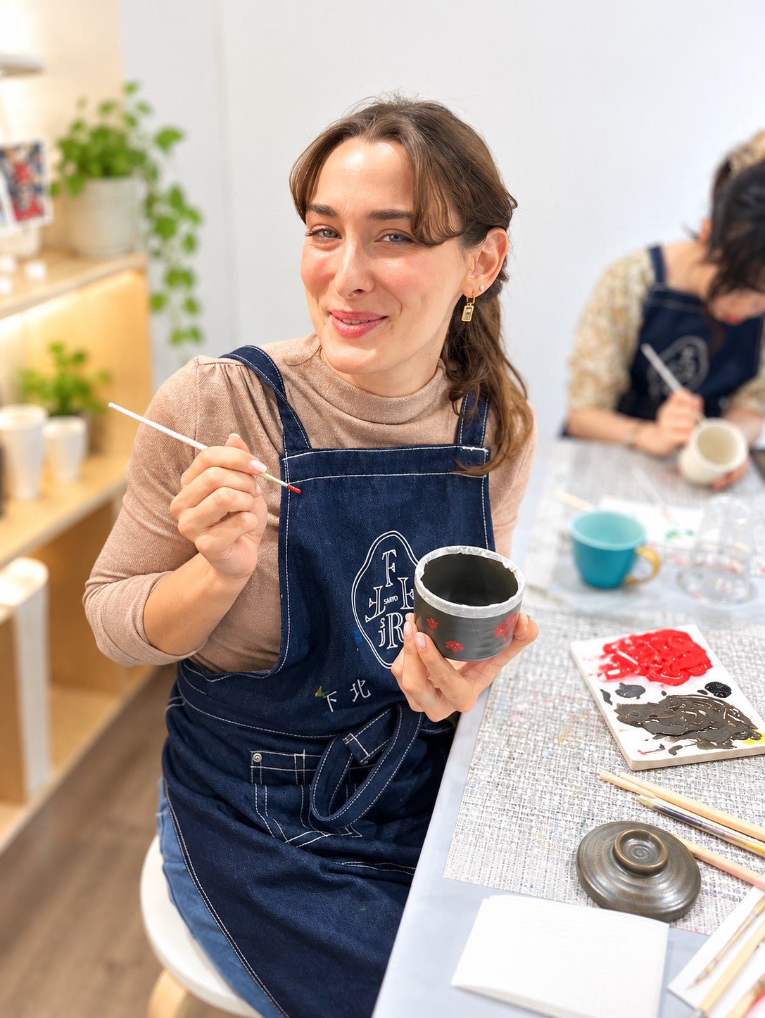 茶寮のエプロンを着用したお客様の茶器絵付け風景